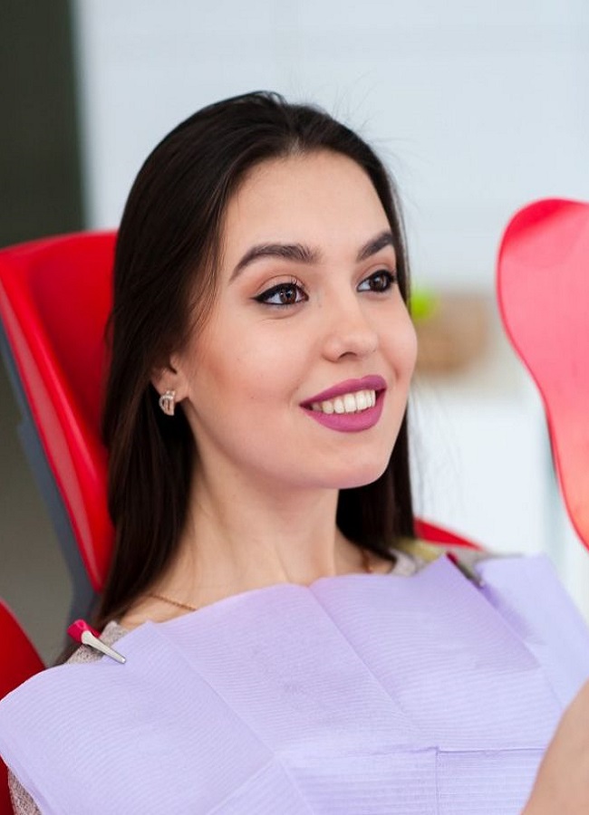 Woman with perfect smile looking at mirror